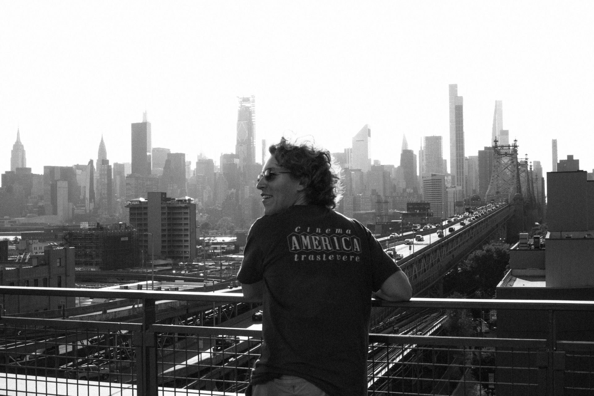 Man overlooking the Manhattan skyline from a rooftop, New York, black and white